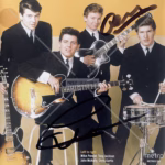 John McNally Autograph on The Searchers – The Very Best Of UK CD inlay, co‑signed by Mike Pender, with disc, case and COA from Presley Collectibles.