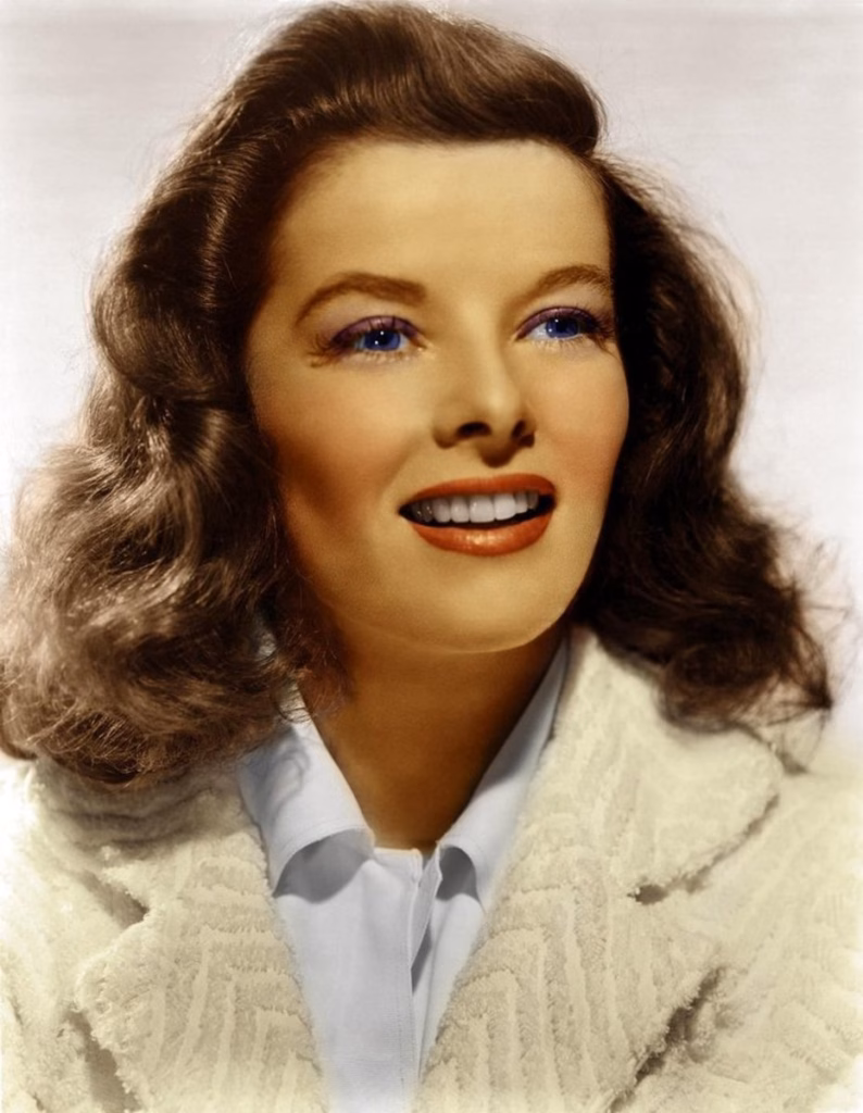 Katharine Hepburn Biography Colourised portrait of Katharine Hepburn wearing a light coat and blue shirt; this image is part of the authenticated memorabilia range at Presley Collectibles, included in the May 2016 15% discount